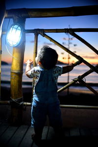 Rear view of boy standing on walkway