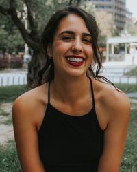 Close-up portrait of cheerful young woman at park