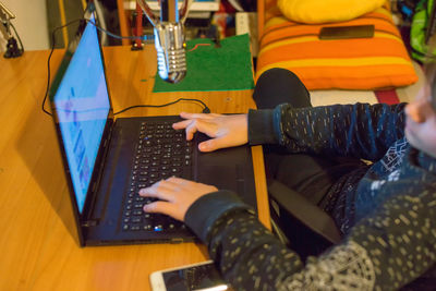 Midsection of man using mobile phone while sitting on table