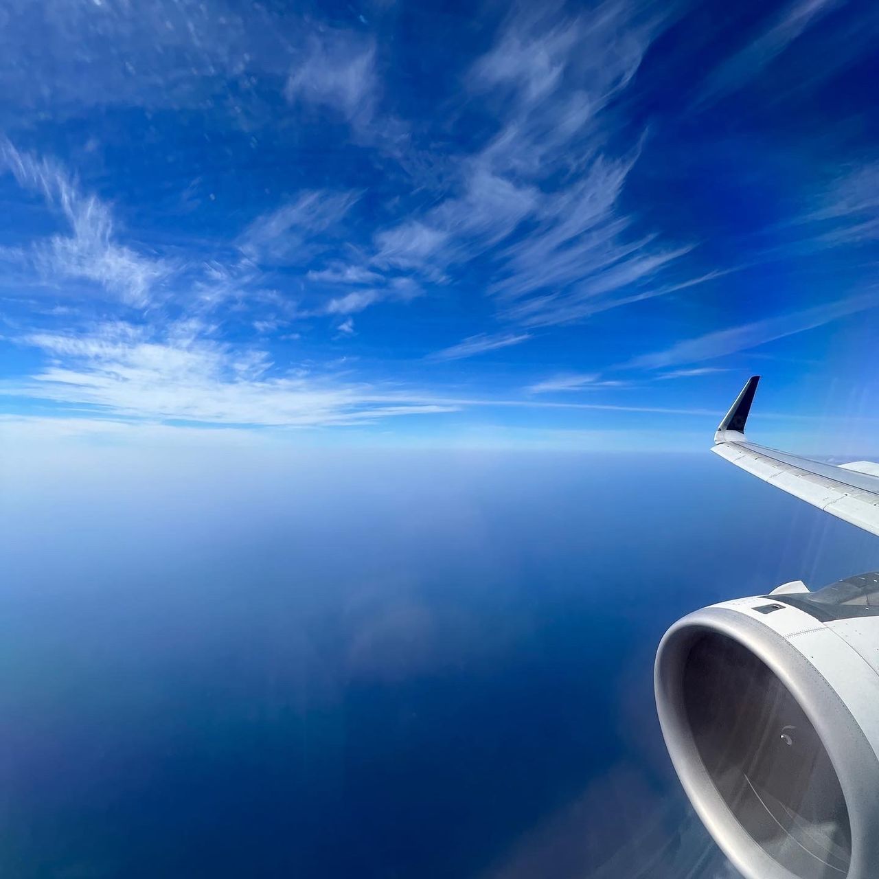 airplane, air vehicle, sky, transportation, flying, aircraft wing, travel, mode of transportation, cloud, blue, air travel, cloudscape, aerial view, nature, journey, horizon, mid-air, environment, engine, vehicle, urban skyline, scenics - nature, jet engine, aircraft, water, sea, motion, aviation, no people, business travel, beauty in nature, outdoors, copy space, vacation, holiday, trip, atmosphere, window, high up, wing, travel destinations, space, wind, landscape, technology, aerospace industry, horizon over water, looking, business, on the move