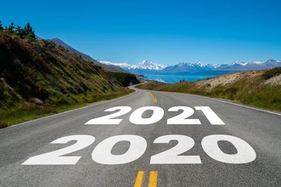 Text on road by mountain against sky