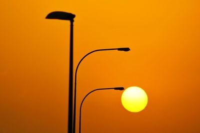 Street light against orange sky