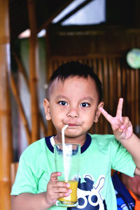 Portrait of a boy drinking juice and looking at the camera