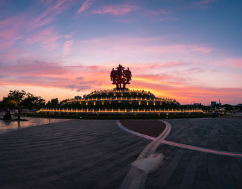 Scenic view of illuminated city against sky at sunset