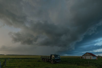 Scenic view of field against cloudy sky