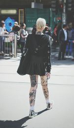 Rear view of woman walking on street in city