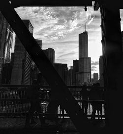 Buildings in city against cloudy sky