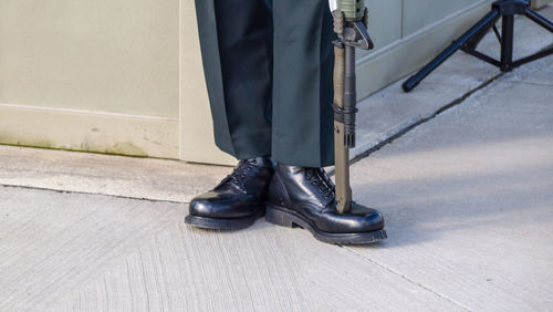 Low section of military man with rifle standing on street