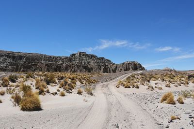 Panoramic view of empty road against blue sky