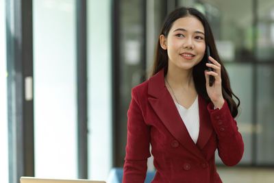 Smiling young businesswoman talking on phone 