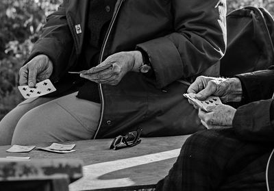 Midsection of people playing cards