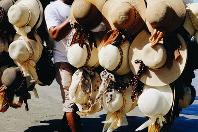 Midsection of man carrying hats