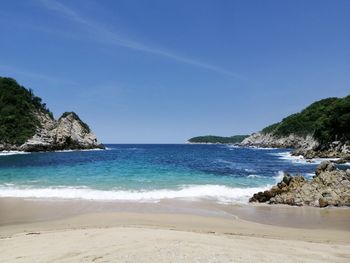 Scenic view of beach against blue sky