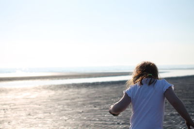 Rear view of woman walking on beach