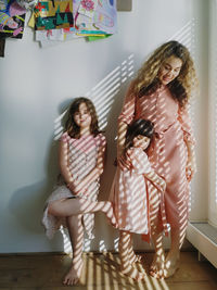 Full length of mother with children  standing at home