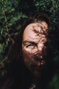 Close-up portrait of woman against trees