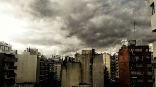 Buildings against cloudy sky