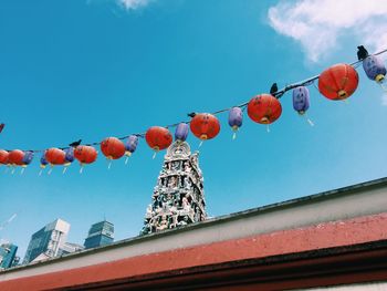 Low angle view of lanterns hanging against sky