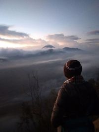 Rear view of man looking at sunset sky