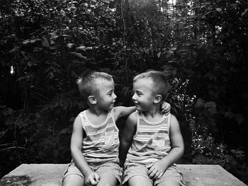 Happy smiling boys sitting again plants