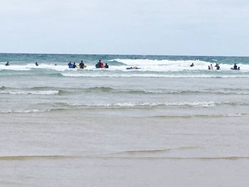 People on beach against sky