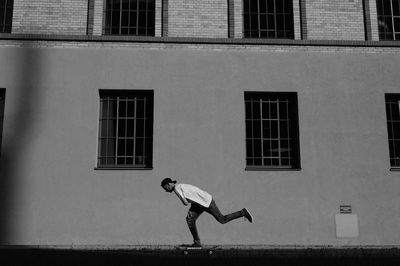 Full length of man on window in city