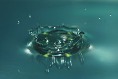Close-up of drop falling on blue water