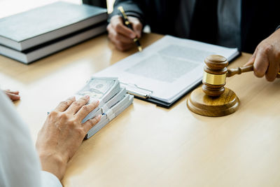 Midsection of man holding camera on table