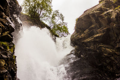 Low angle view of waterfall against sky