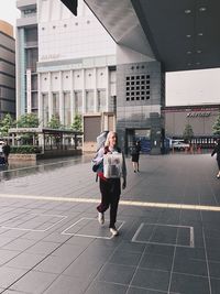 Young woman with backpack walking on street