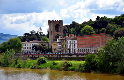 Built structure by river against buildings