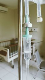 Close-up of iv drip drop with saline in hospital