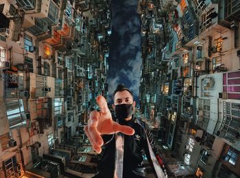 Digital composite image of man standing by illuminated buildings in city