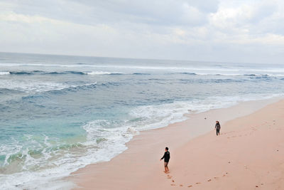 People on beach against sky