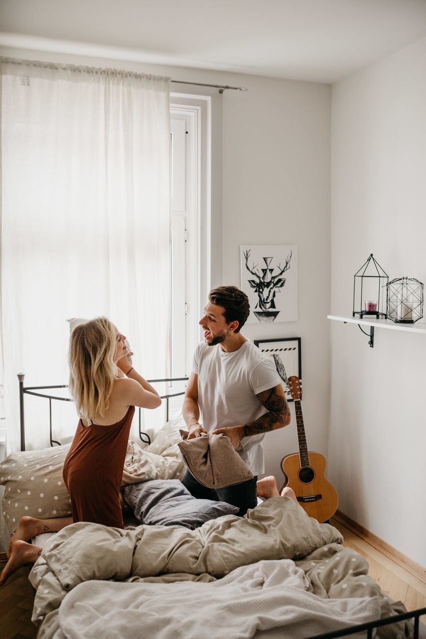 WOMAN SITTING ON BED AT HOME