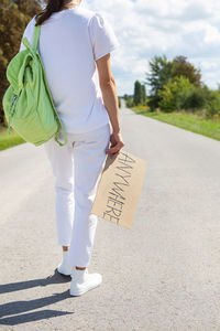 Rear view of woman walking on road