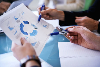 Midsection of business people working on table