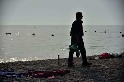 Man standing on beach against clear sky