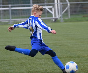 Full length of boy playing soccer on field