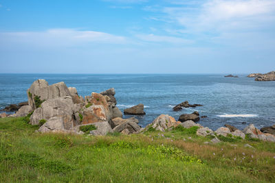 Rocks by sea against sky