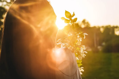 Rear view of woman standing against orange sky