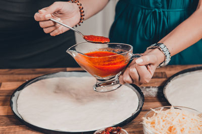 Midsection of woman holding drink on table