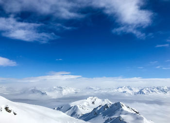 Scenic view of snowcapped mountains against blue sky