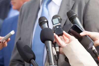 Cropped image of journalists interviewing businessman