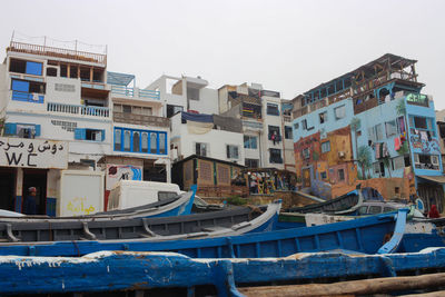 Boats moored in city against clear sky