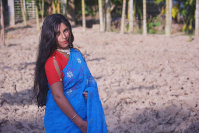 Portrait of beautiful woman standing on land