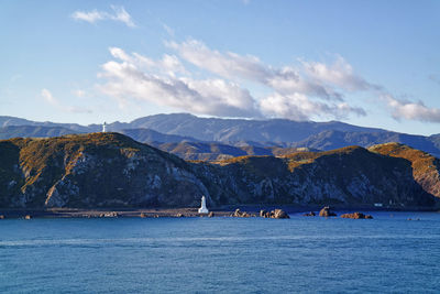 Scenic view of sea by mountains against sky