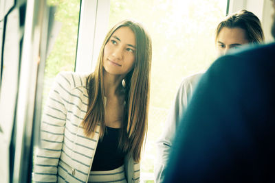 Portrait of a young woman looking at window