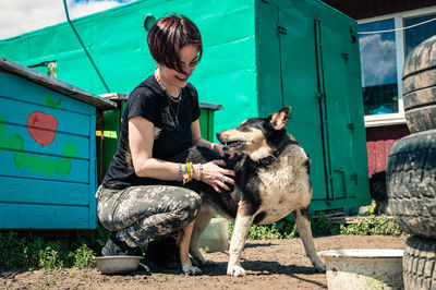 Portrait of woman with dog on field