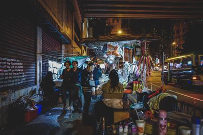 People in illuminated market at night